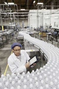 High angle view of man examining bottles at bottling plant
